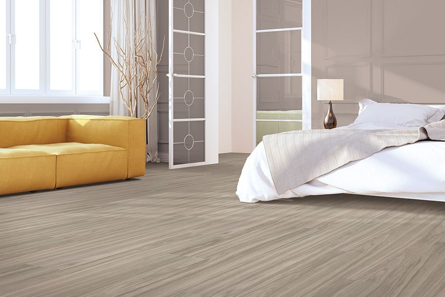 Bedroom with modern grey waterproof flooring and cozy yellow sofa