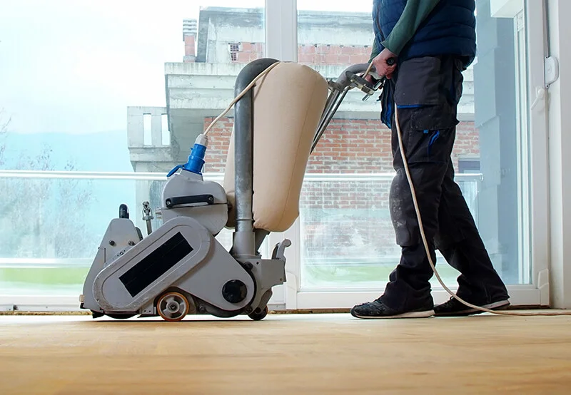 Person sanding hardwood flooring